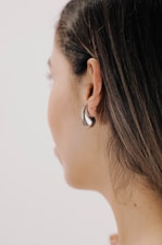 a close up of a person wearing a pair of earrings