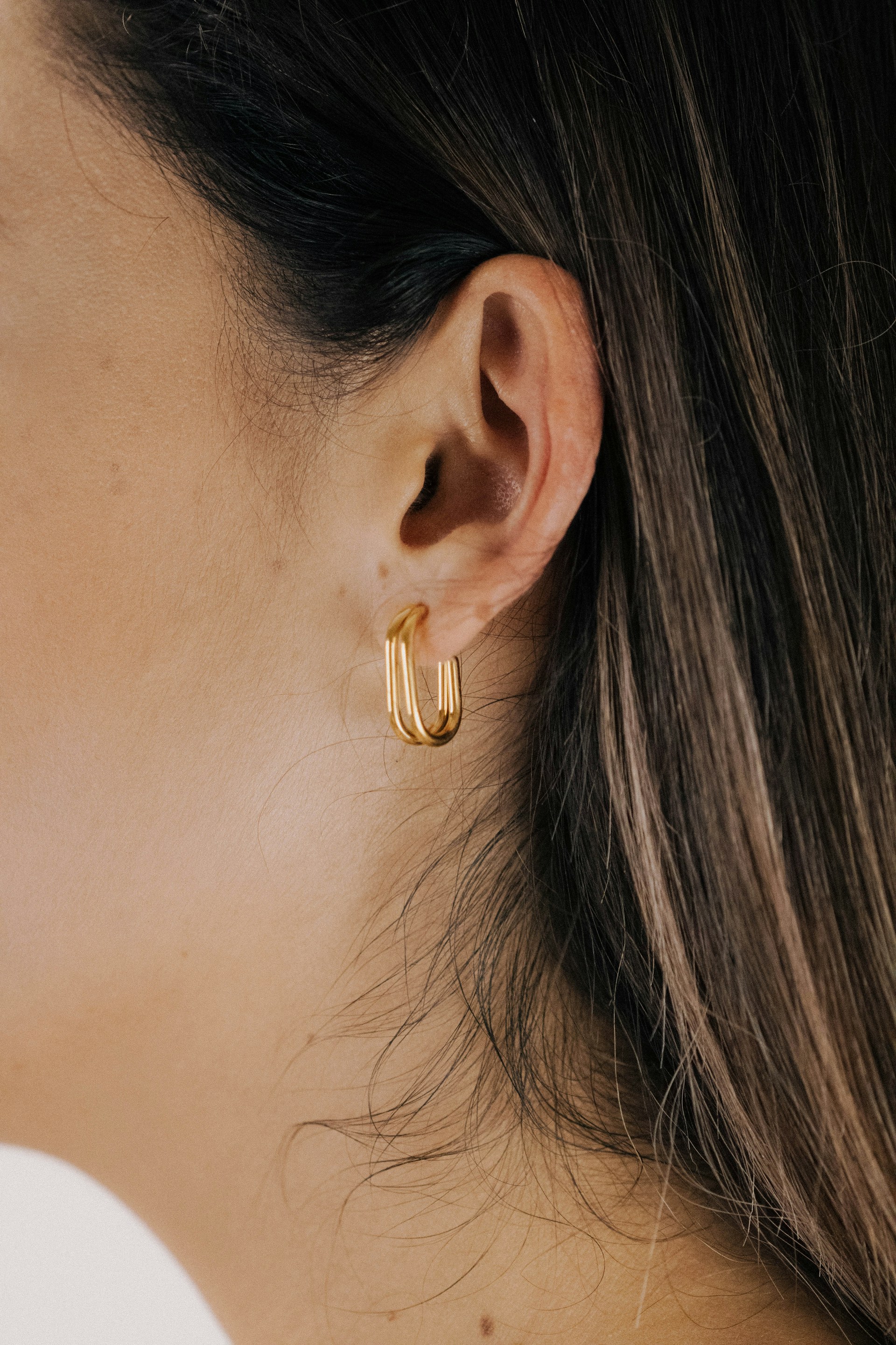 a close up of a person wearing a pair of earrings