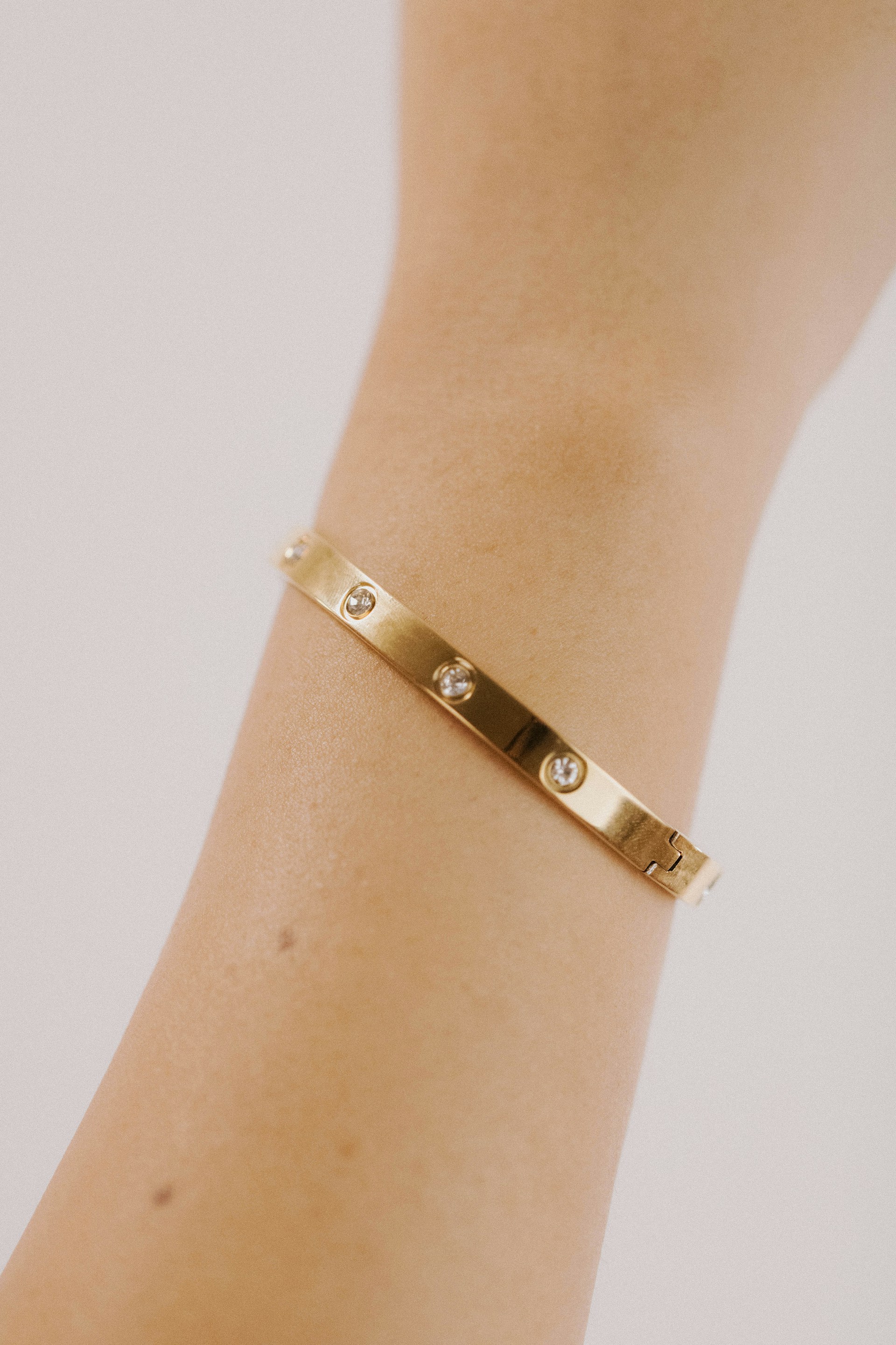 a woman's arm with a gold bracelet on it