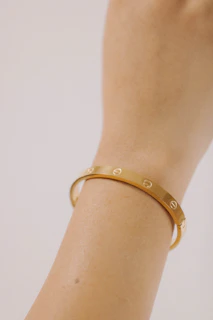 a close up of a person wearing a gold bracelet