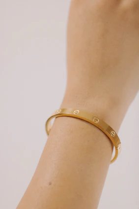 a close up of a person wearing a gold bracelet