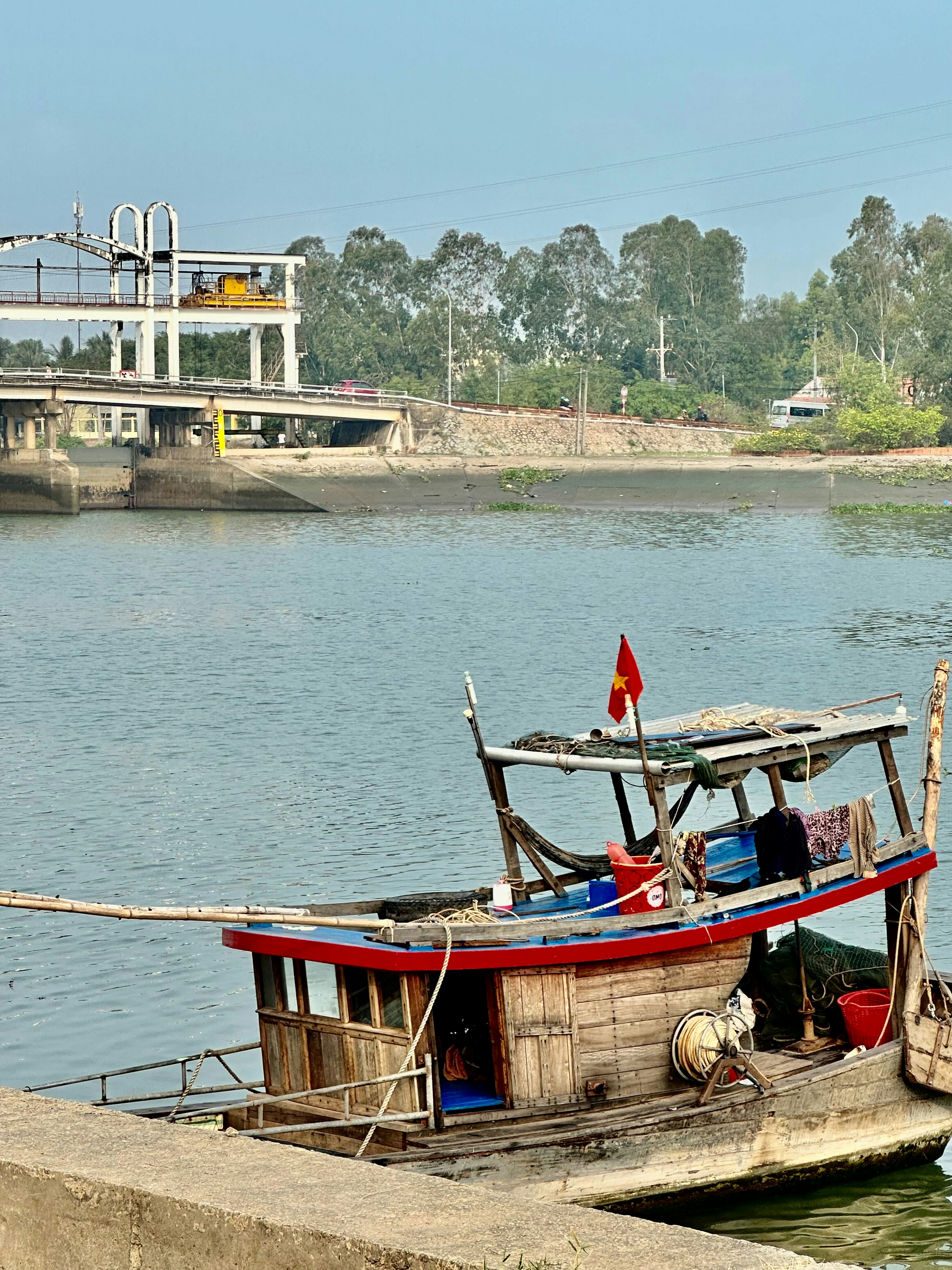 Local Vietnamese family on traditional wooden boat on calm lake, authentic community connection, warm natural light