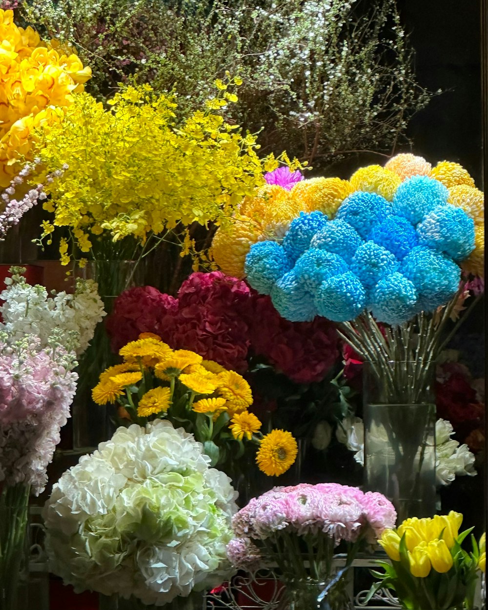 ein Strauß verschiedenfarbiger Blumen in Vasen