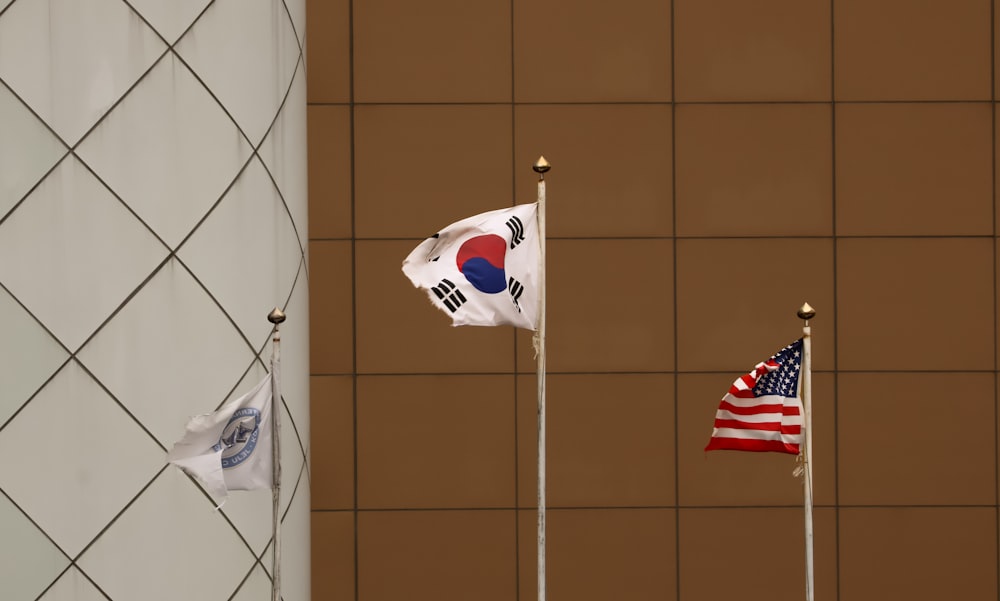 a group of three flags flying next to each other