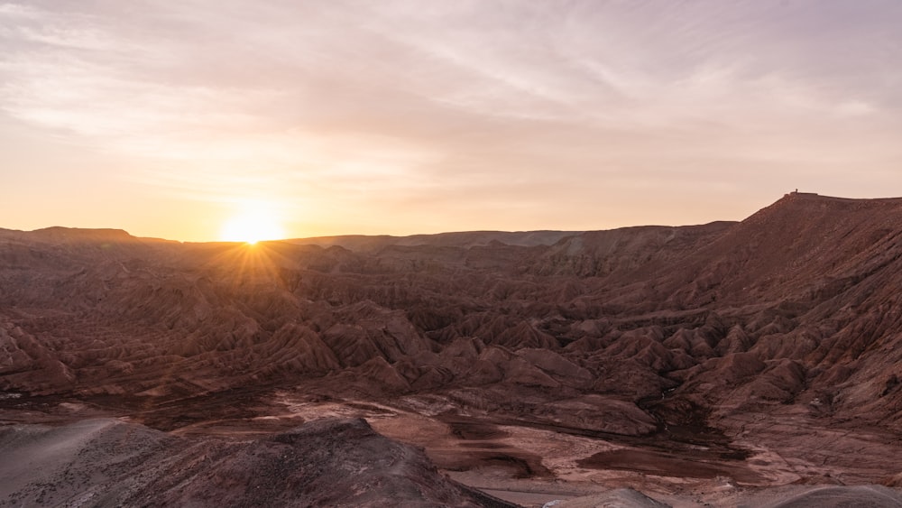 the sun is setting over the mountains in the desert