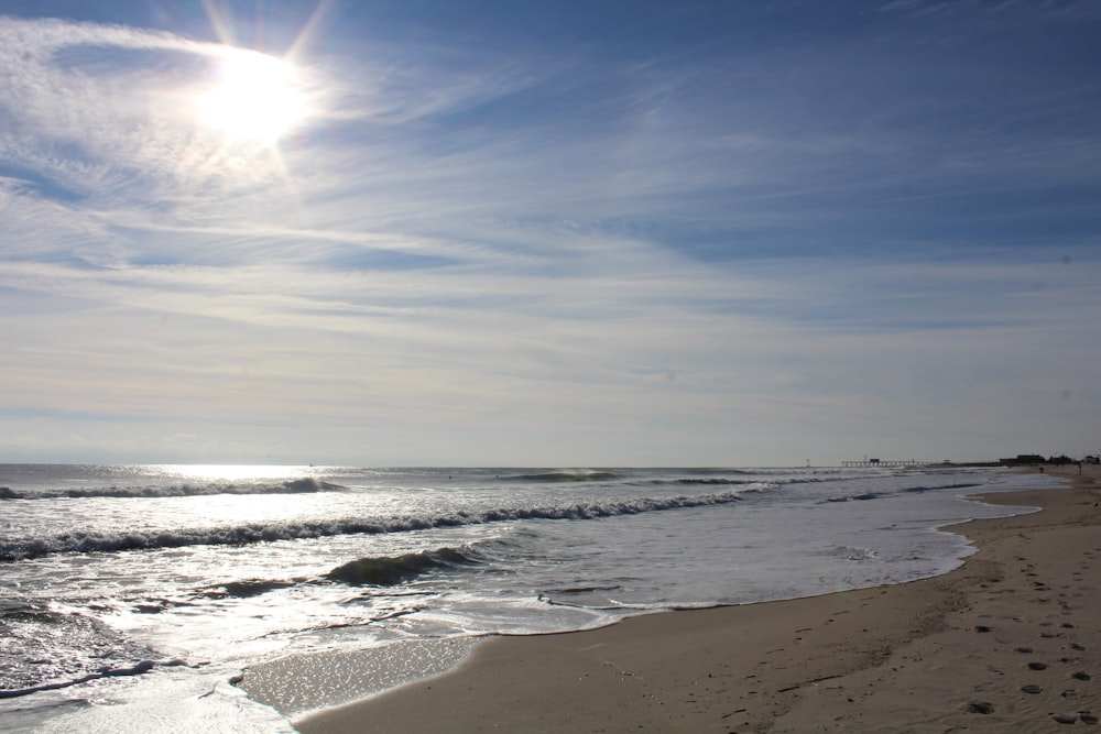 the sun is shining over the ocean on the beach