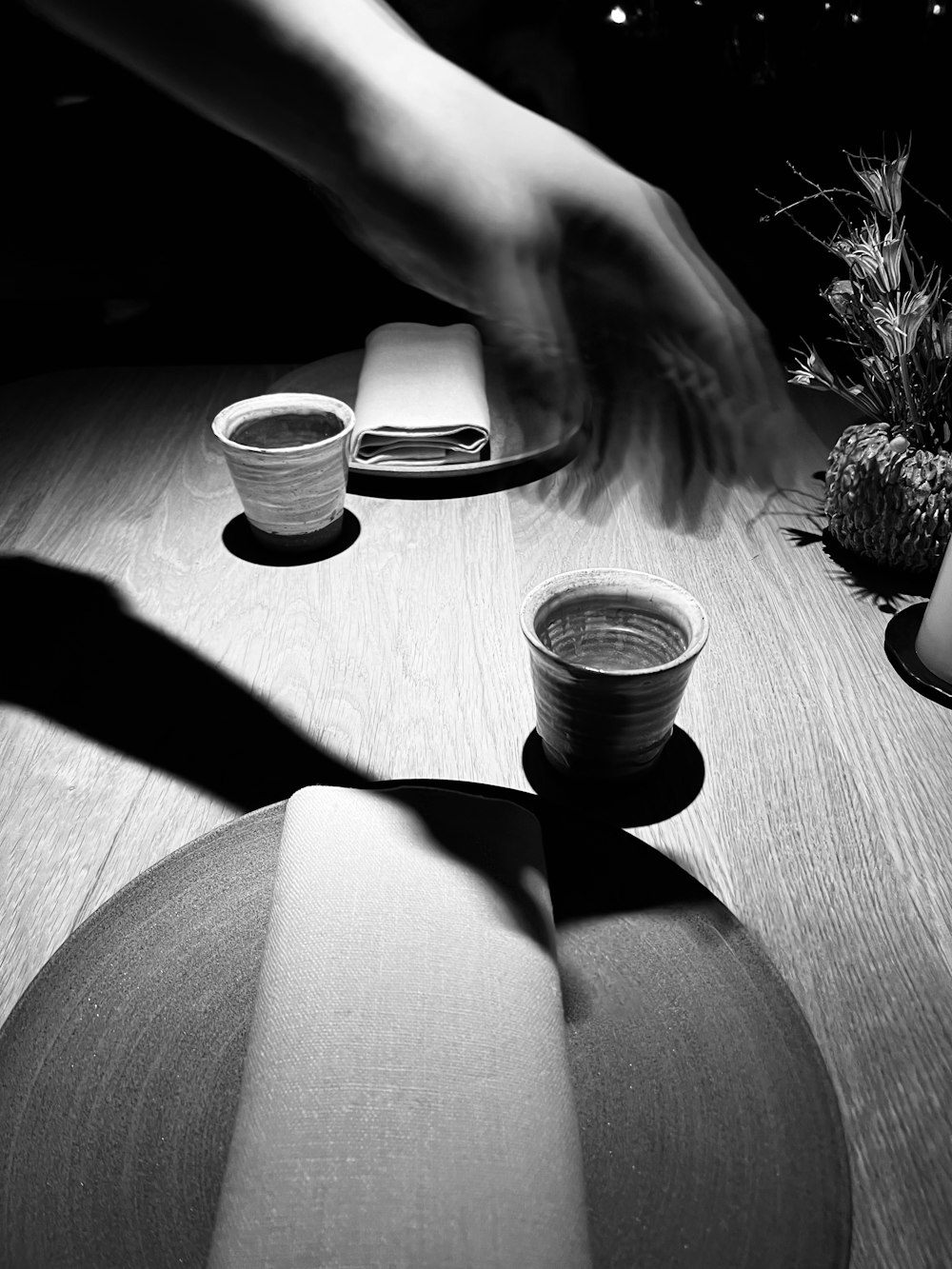 a person reaching for a cup on a table