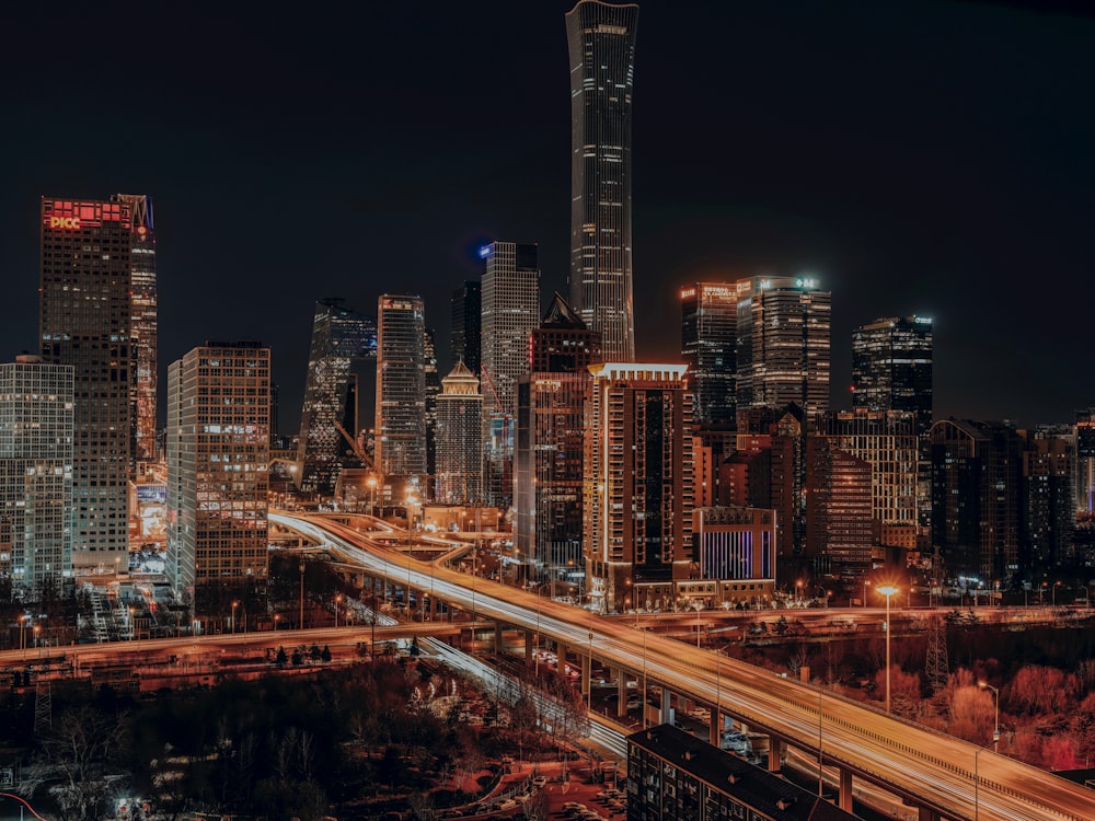 a city skyline at night with a freeway going through it