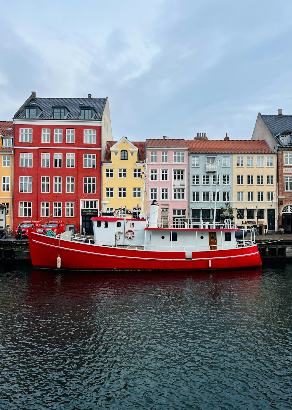 a red and white boat sitting in the water