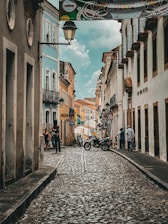 a cobblestone street with a motorcycle parked on the side