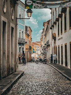 a cobblestone street with a motorcycle parked on the side