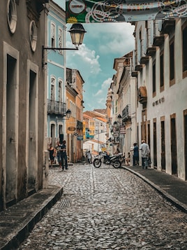 a cobblestone street with a motorcycle parked on the side