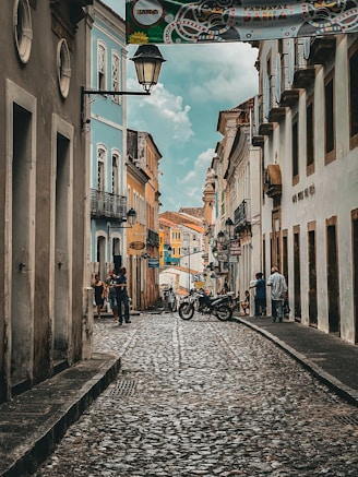 a cobblestone street with a motorcycle parked on the side