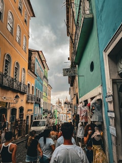 a group of people walking down a street next to tall buildings