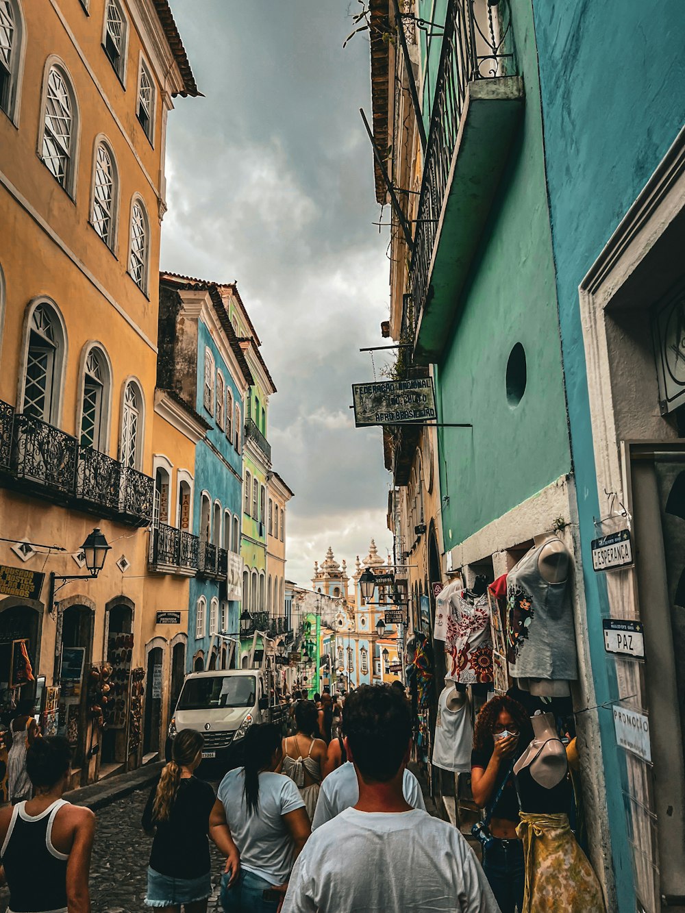 a group of people walking down a street next to tall buildings