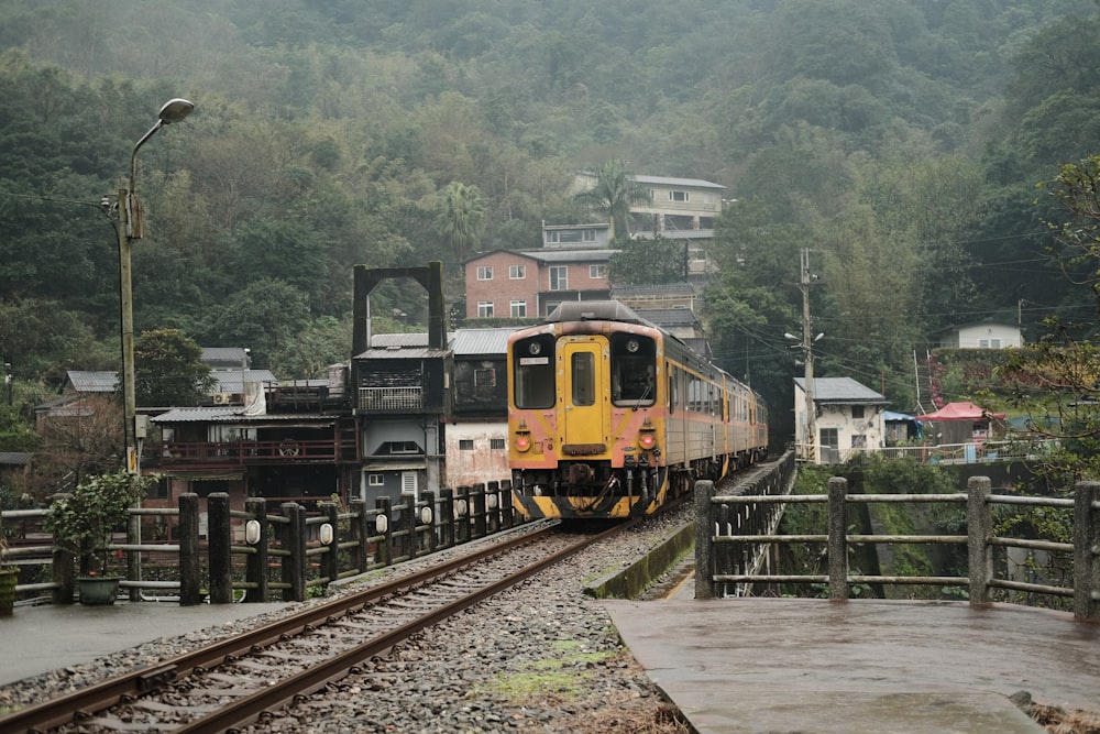 Un tren amarillo y negro viajando por las vías del tren