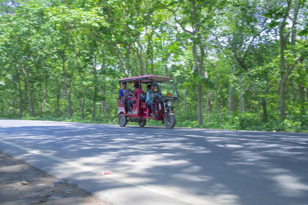 two people riding in a rickshaw on a road