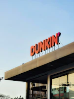 a dunkin'donuts sign on top of a building