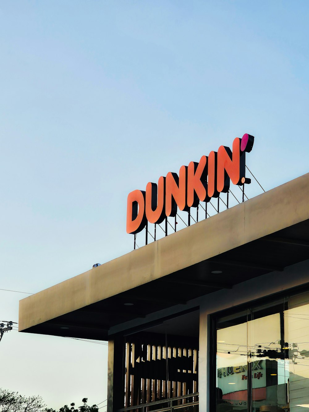 a dunkin'donuts sign on top of a building