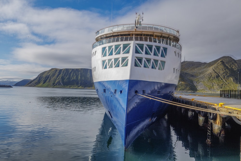 a large blue and white boat docked at a dock