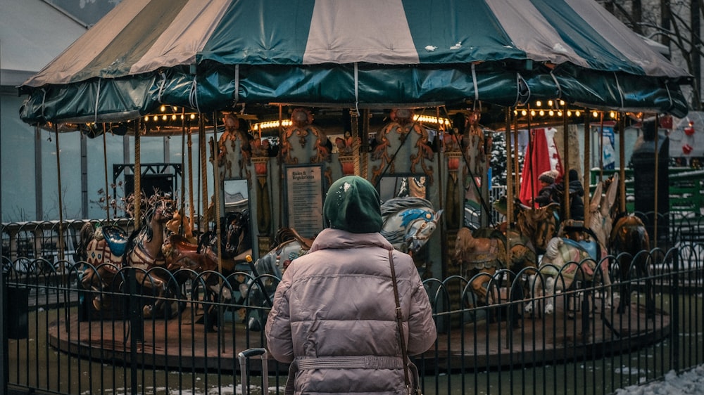 a person standing in front of a merry go round