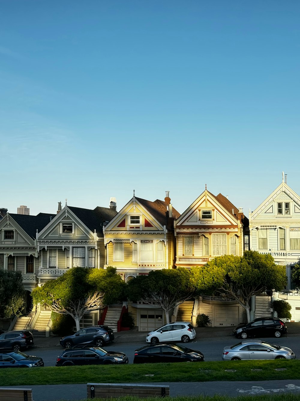 a row of houses with cars parked in front of them