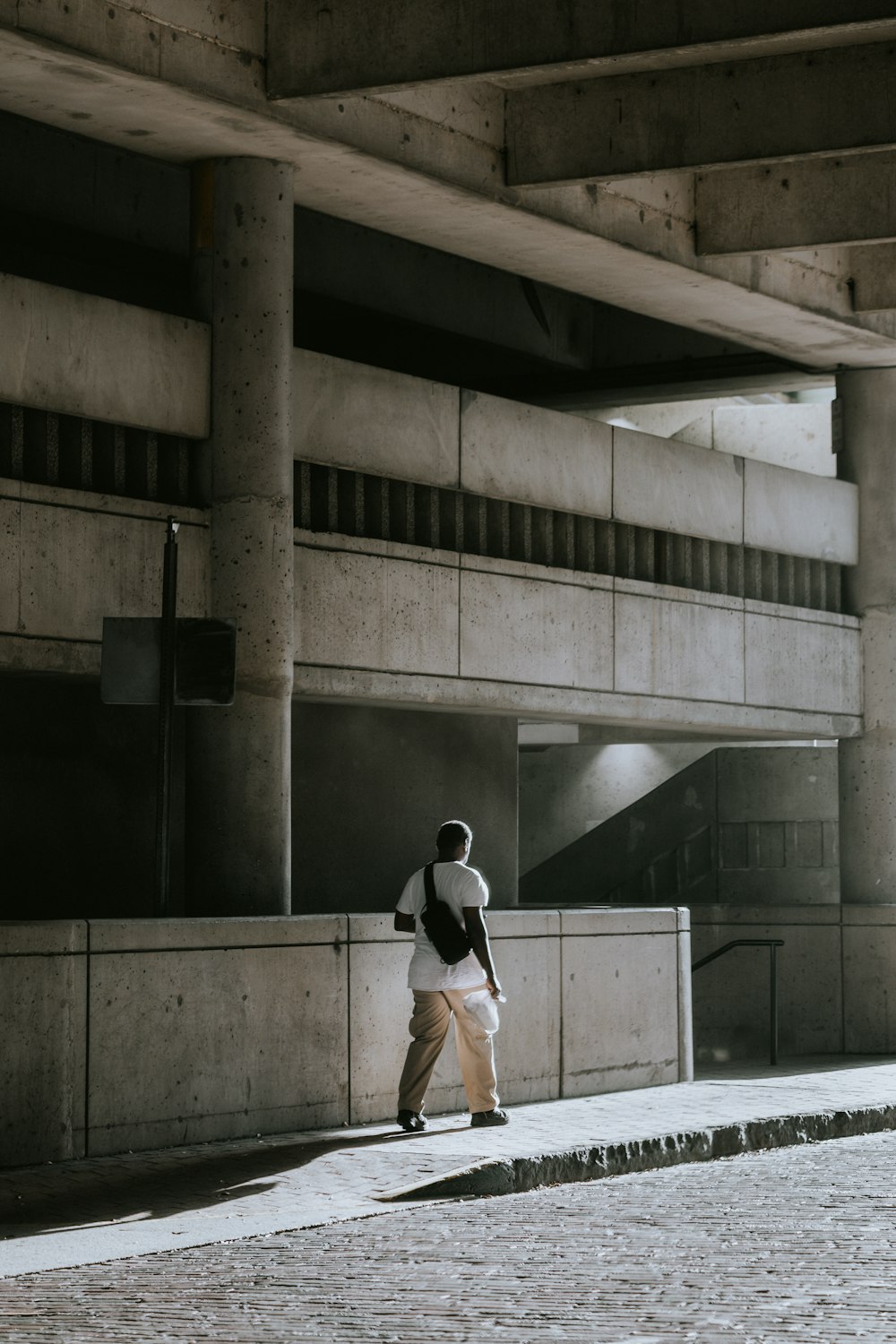 a man walking down a sidewalk next to a building