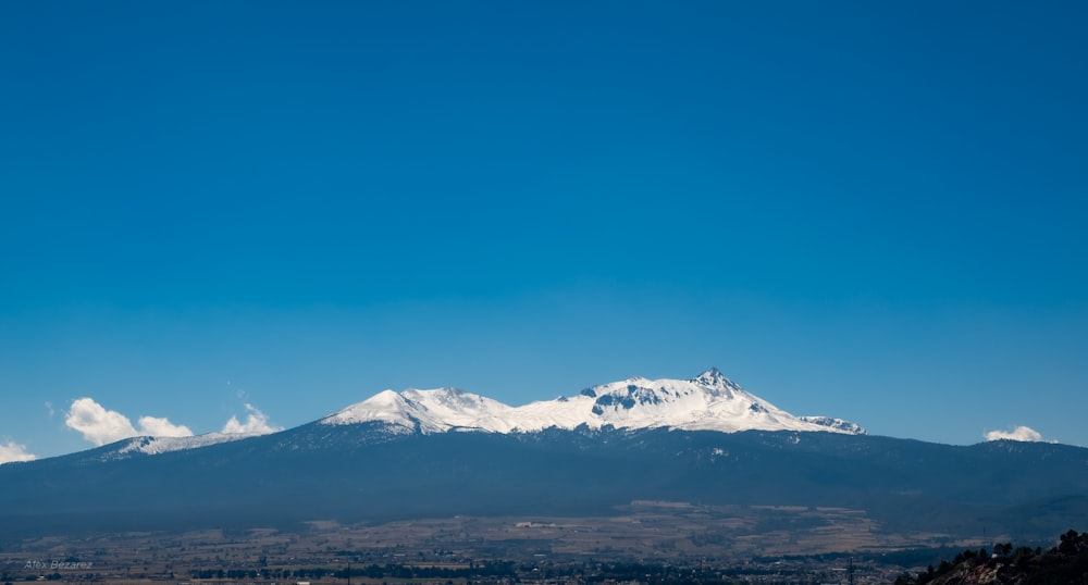a snow covered mountain in the distance with a clear blue sky