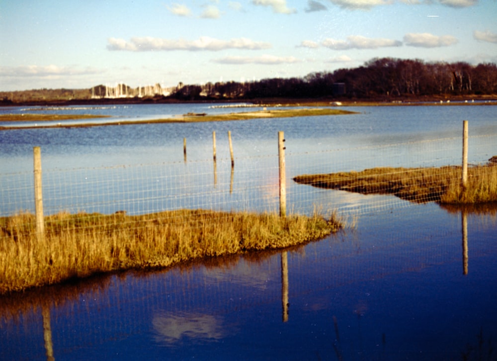 a body of water with a fence in the middle of it