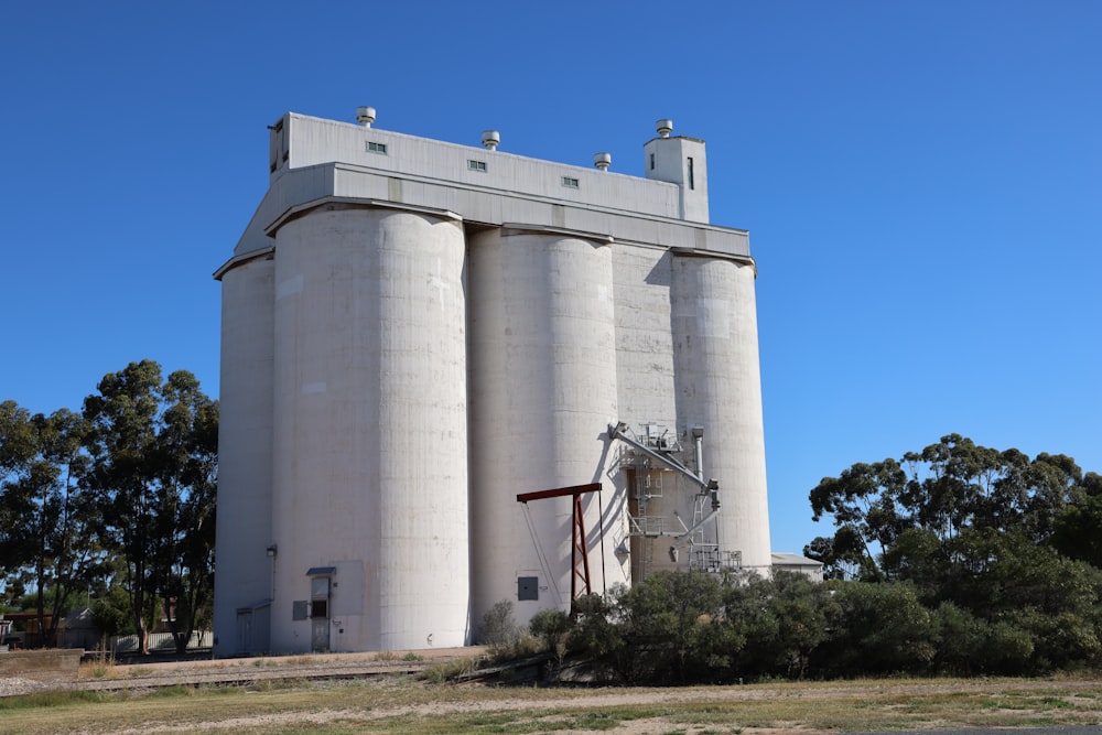 a large white silo sitting on top of a lush green field
