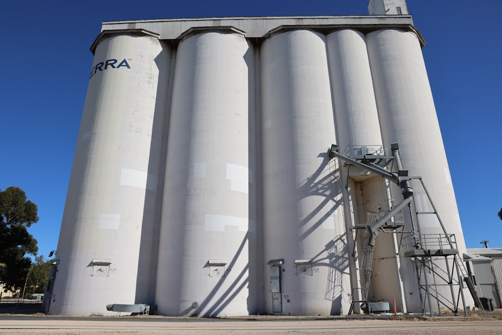 a large white silo sitting next to a tall building