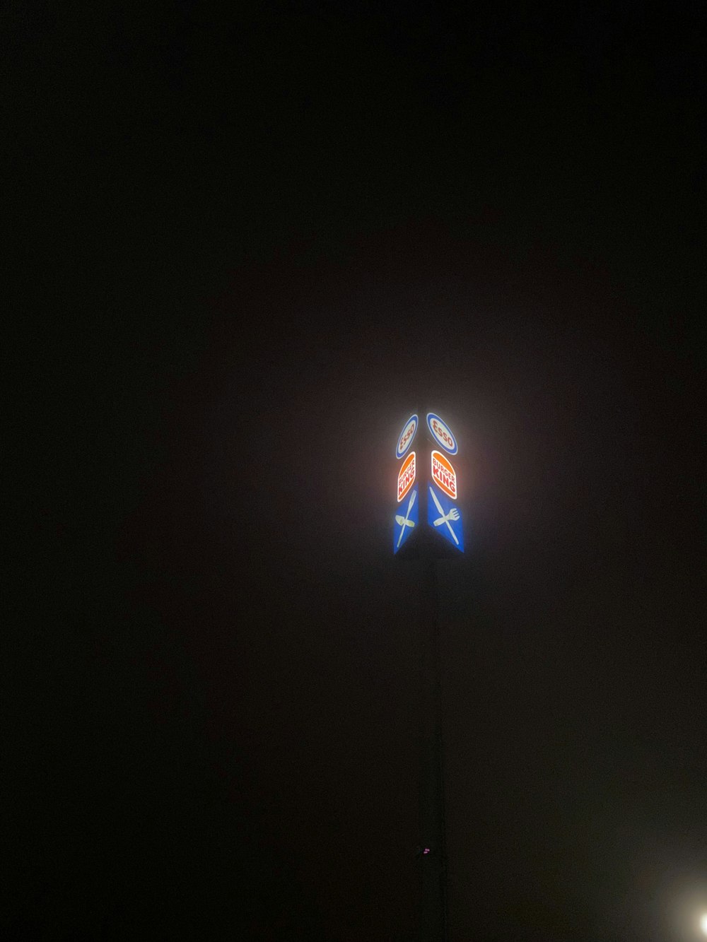 a street light in the dark with a red white and blue arrow on it