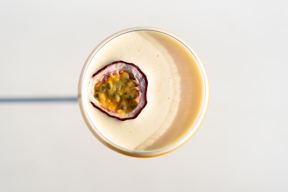 a smoothie in a glass topped with a fruit garnish