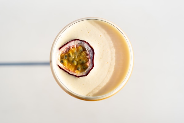 A smoothie in a glass topped with a fruit garnish