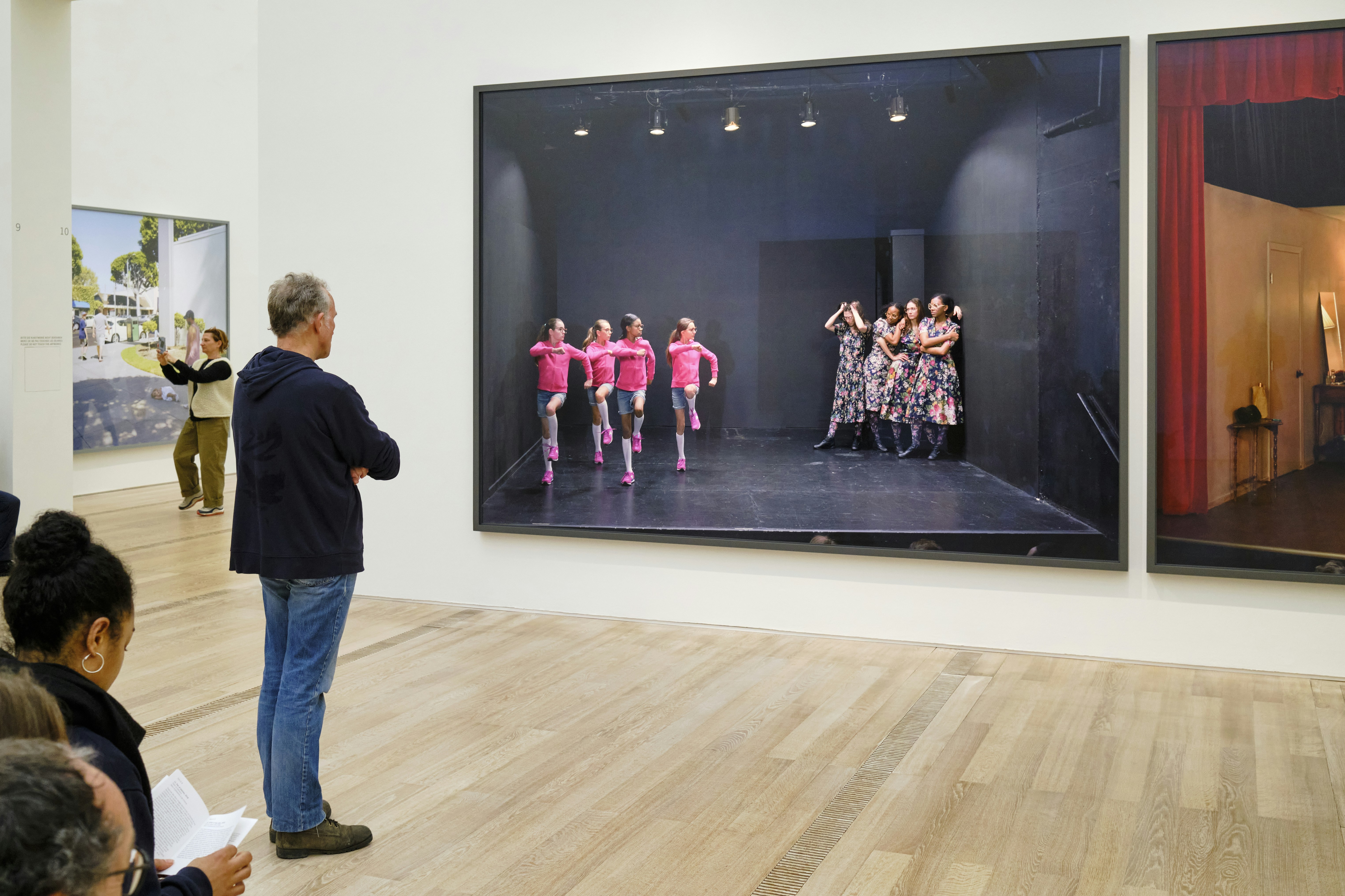 a group of people standing in front of a painting