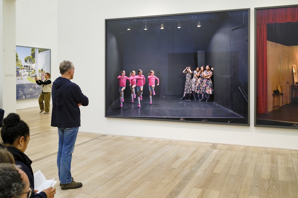 a group of people standing in front of a painting