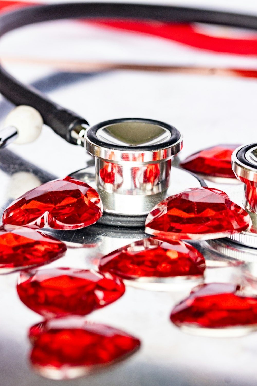 a stethoscope laying on top of a table next to red hearts