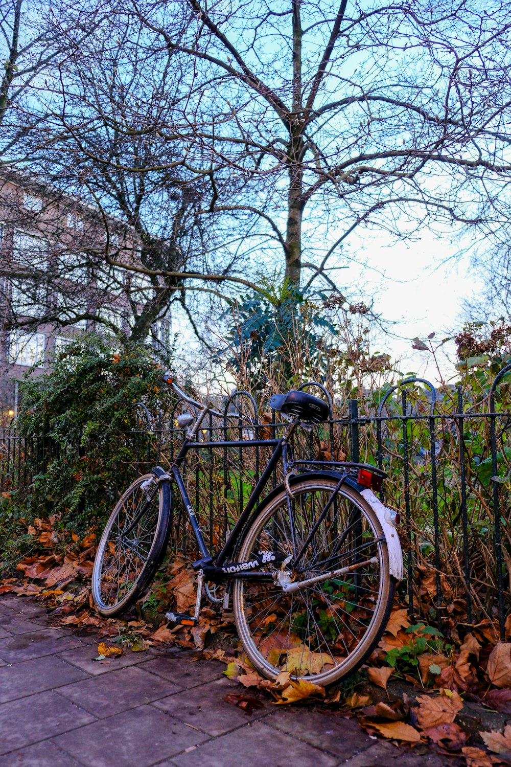 a bicycle is parked next to a fence