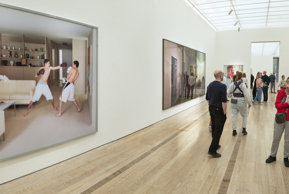 a group of people standing in a museum looking at paintings