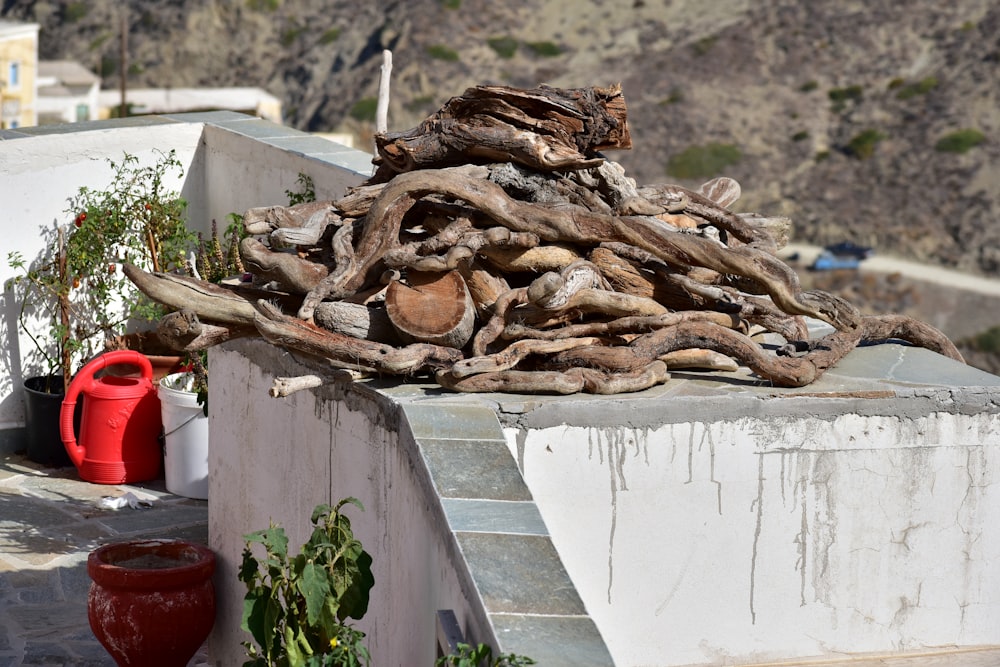 a pile of wood sitting on top of a cement wall