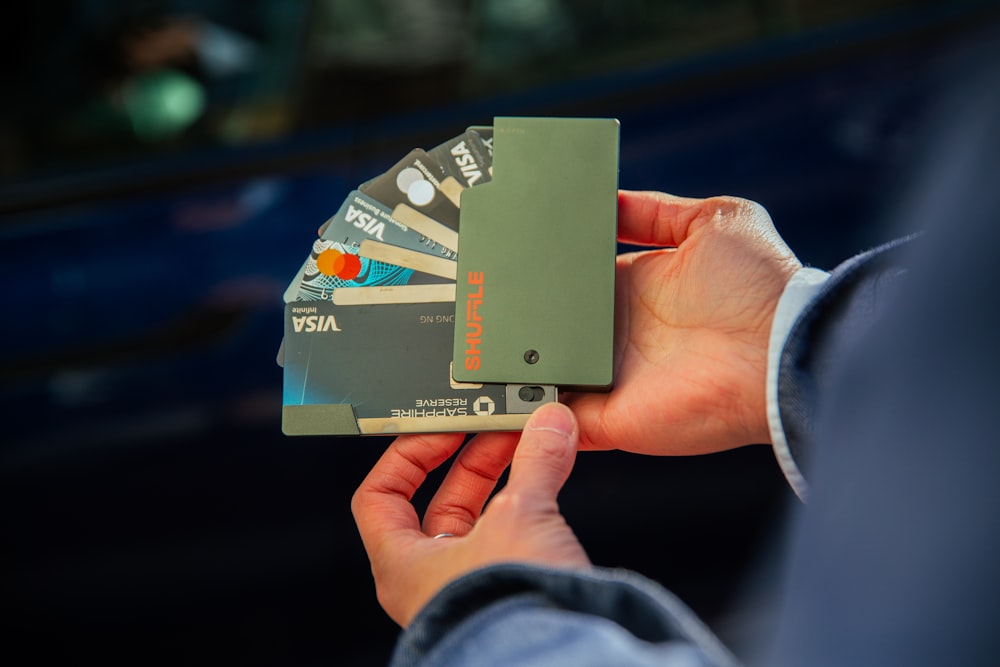 a person holding several credit cards in their hand
