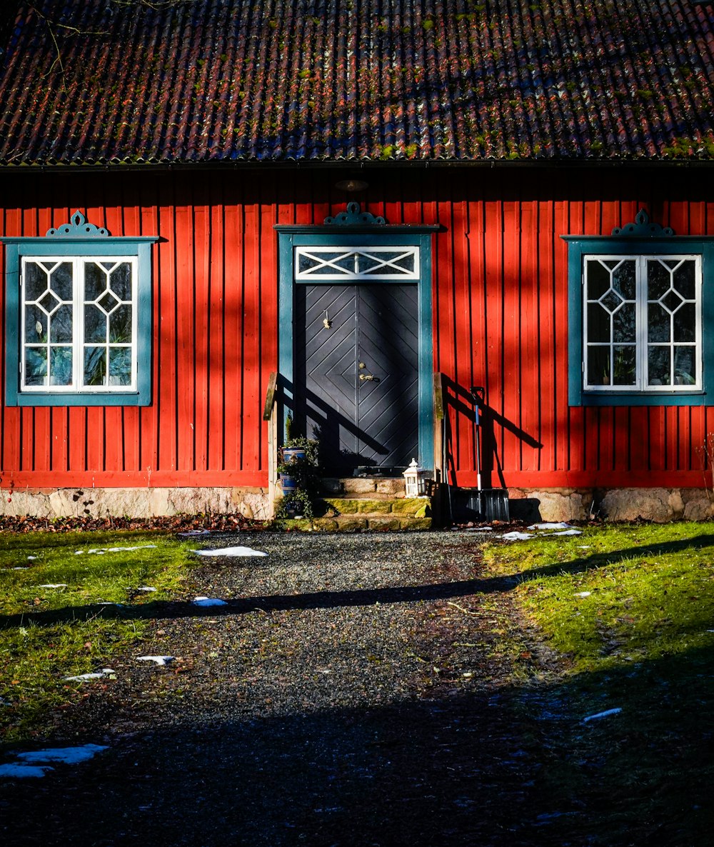 a red house with a black door and windows