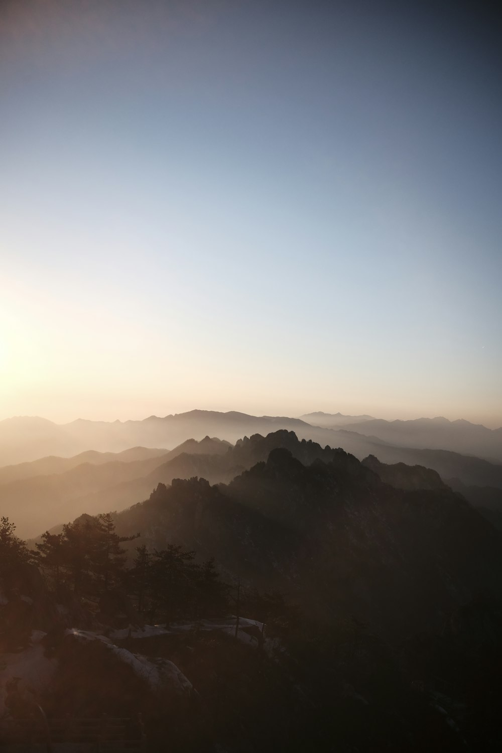 the sun is setting over a mountain range