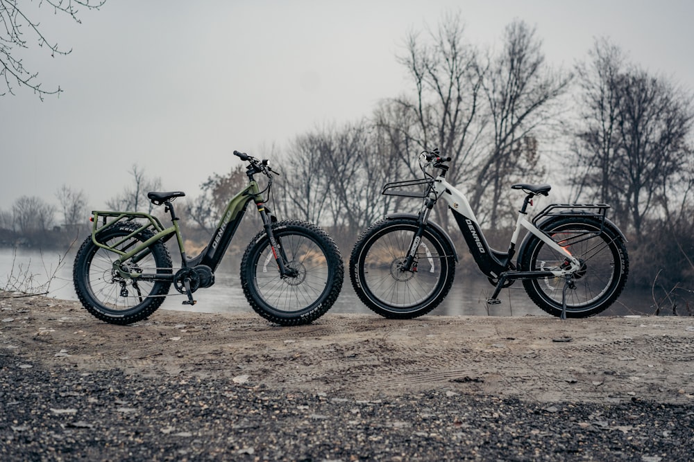 three bikes parked next to each other on a dirt field