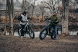a couple of men standing next to each other on dirt bikes