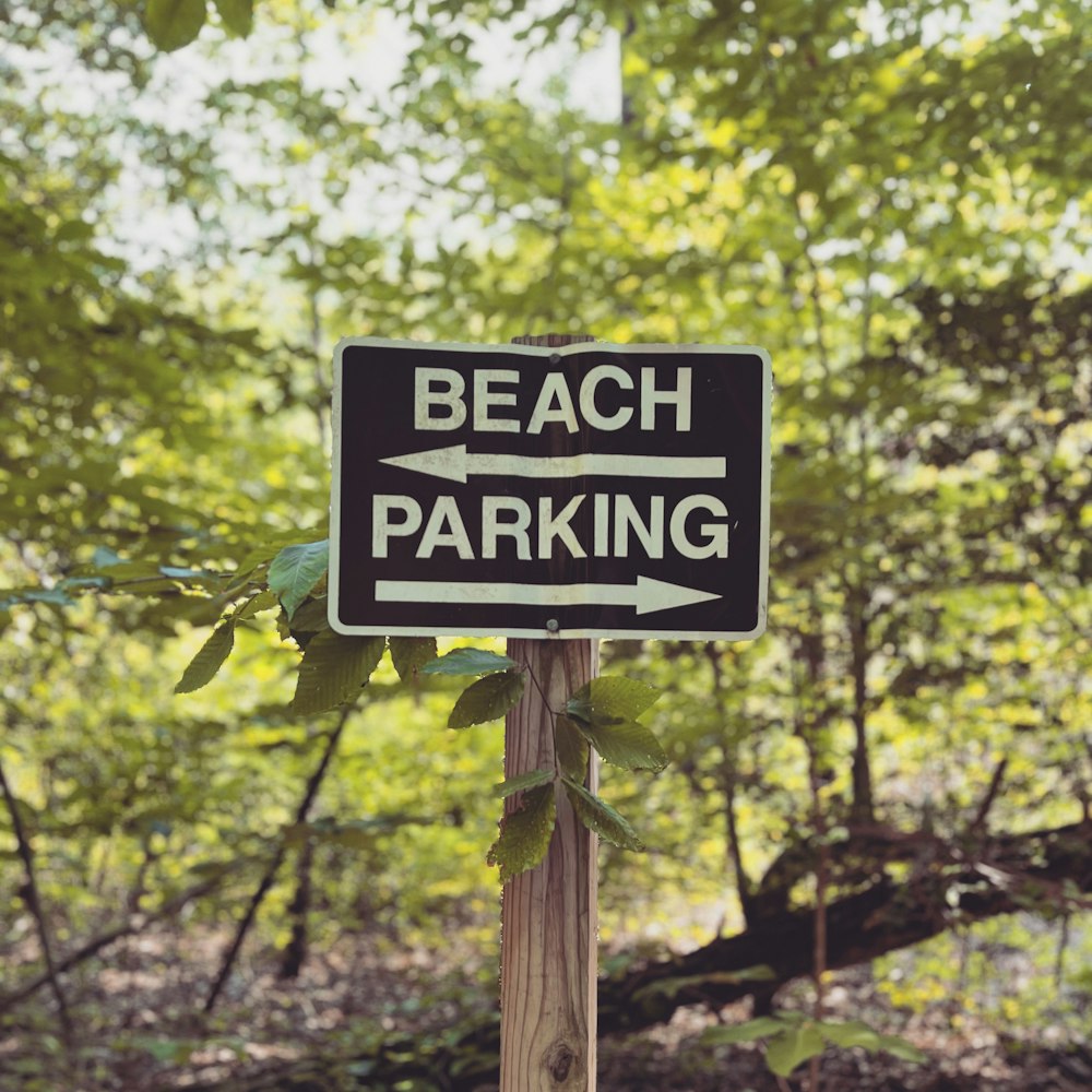 a black and white sign that says beach parking