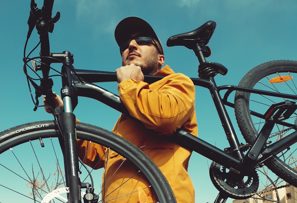 a man standing next to a bicycle with his hand on the back of it