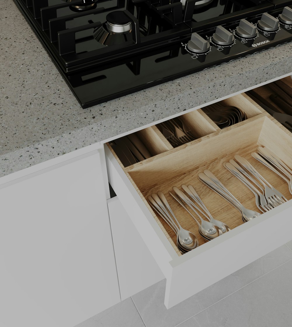 a drawer with utensils and spoons in it