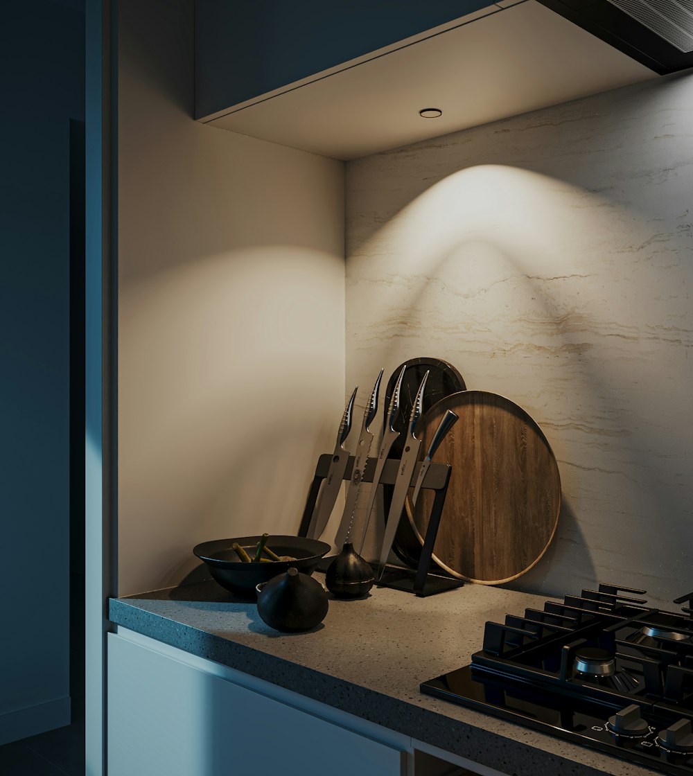 a kitchen with a stove top and a wooden cutting board