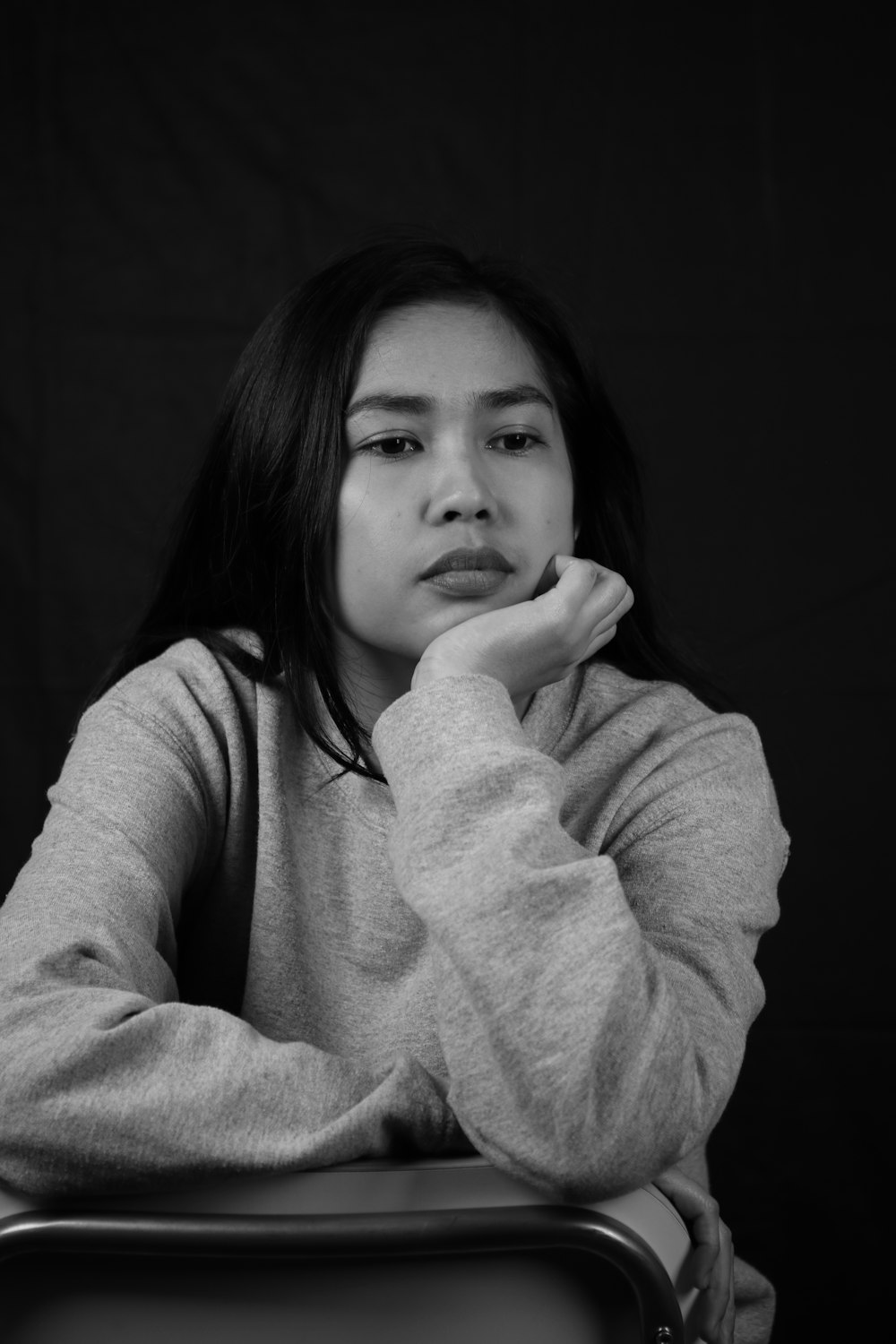 a black and white photo of a woman sitting in a chair